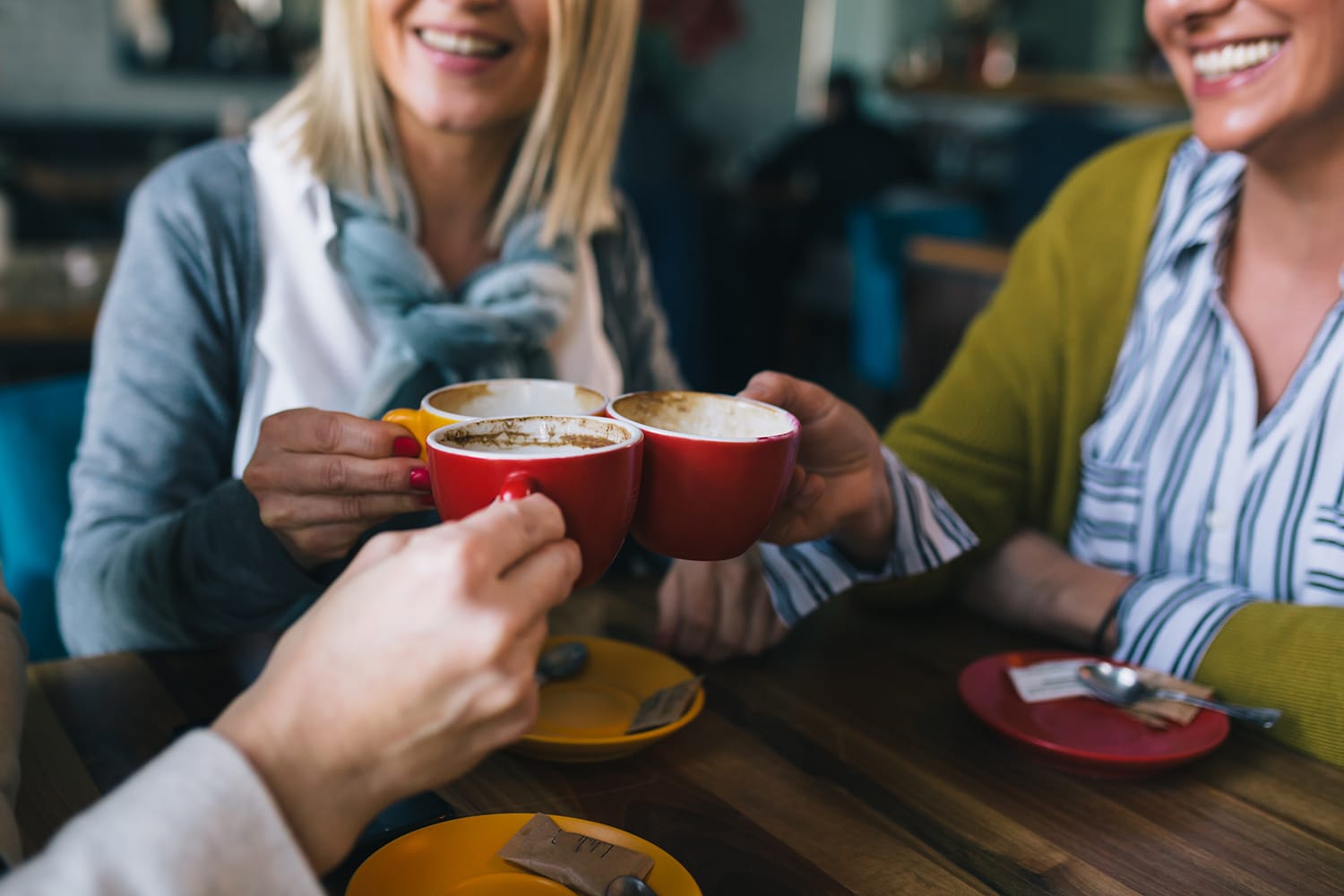 woman friends on coffee break at cafe, cheers with coffee